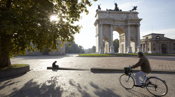 A woman reads at the Arco della Pace in Milan, Italy.